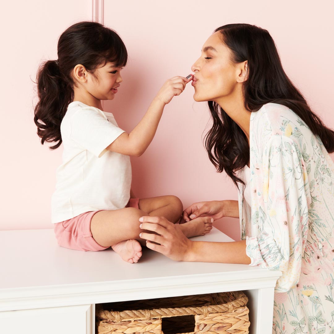 Daughter putting make up on mother