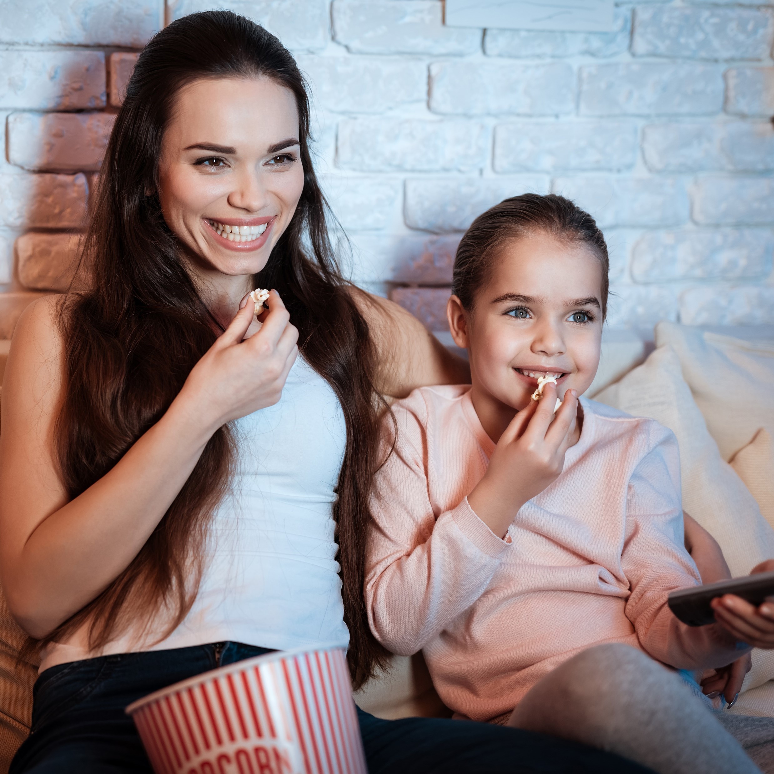 A mom and a Daughter eating popcorn together